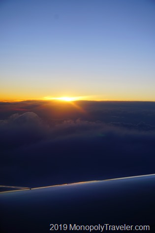 A setting sun from above the clouds